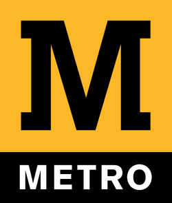 Tyne and Wear Metro logo. On top: yellow square containing black M. On bottom: black strip containing white txt "METRO"